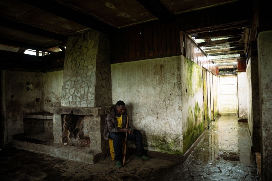 A young farmer takes shelter from the rain in a former hotel in Ruvunda that was bombed by a Congolese army drone in December 2023, Mushaki, DR Congo. (AFP)