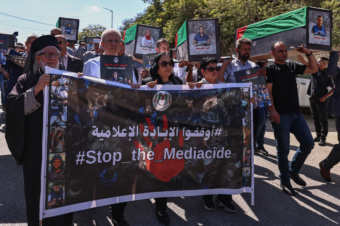 Palestinian journalists and local officials lift symbolic coffins and portraits of media workers killed in Israeli fire as they mark two years since the Gaza war erupted, during a rally calling for accountability. (File/AFP)