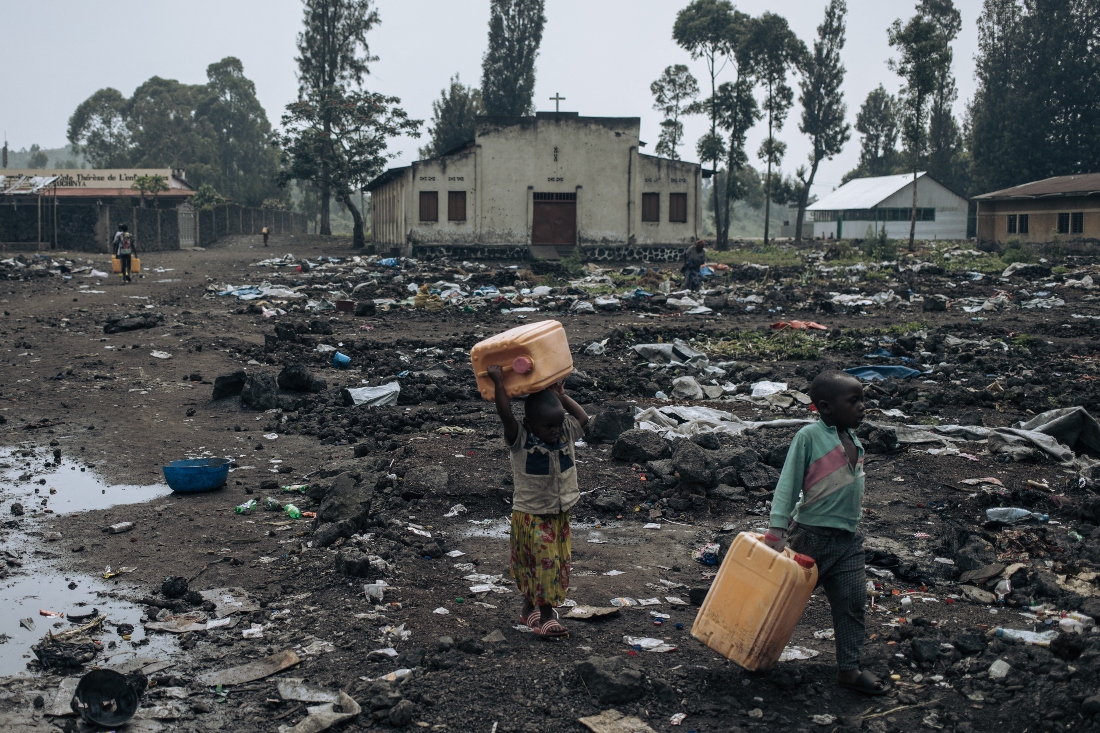 War displaced children carry water as the camps empty of their population in Goma, Congo. (AFP)