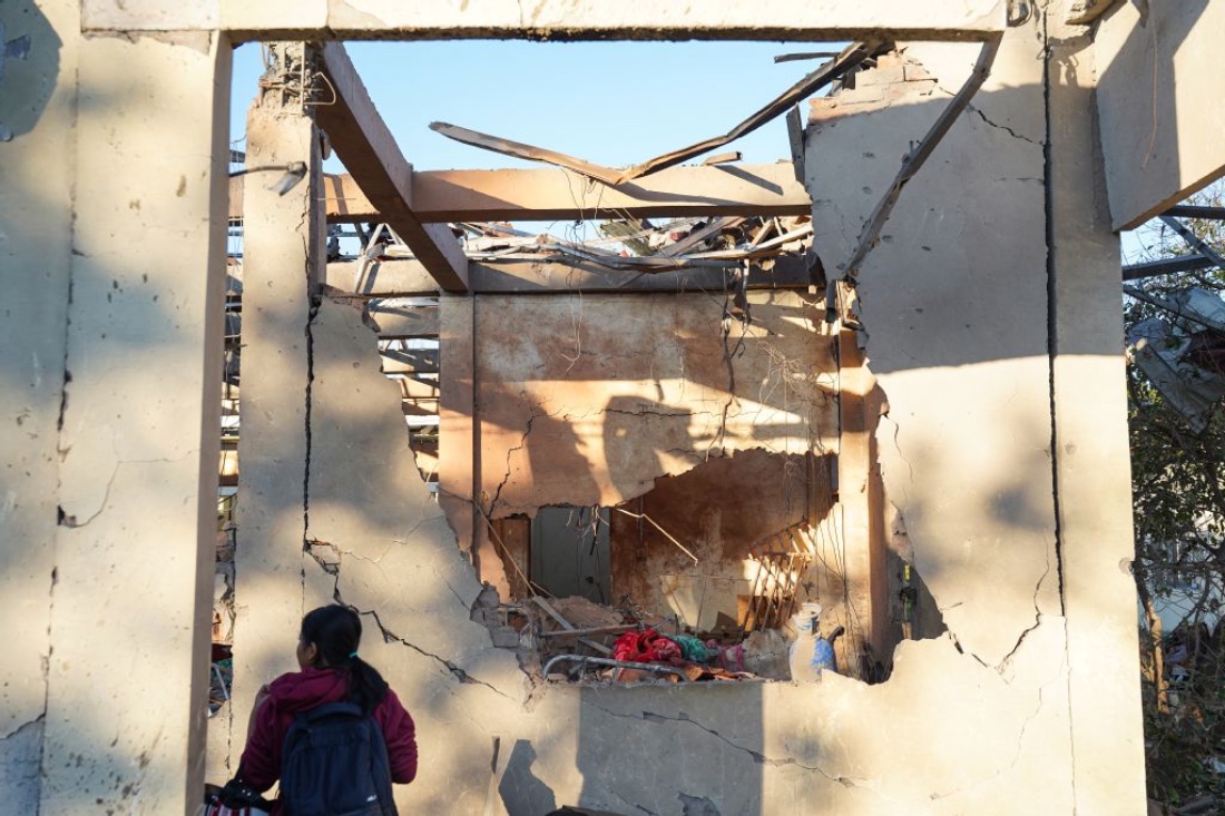 A woman inspects a hospital damaged in a Myanmar military air strike that killed more than 30 people in Mrauk U, western Rakhine state, Myanmar. (AFP)