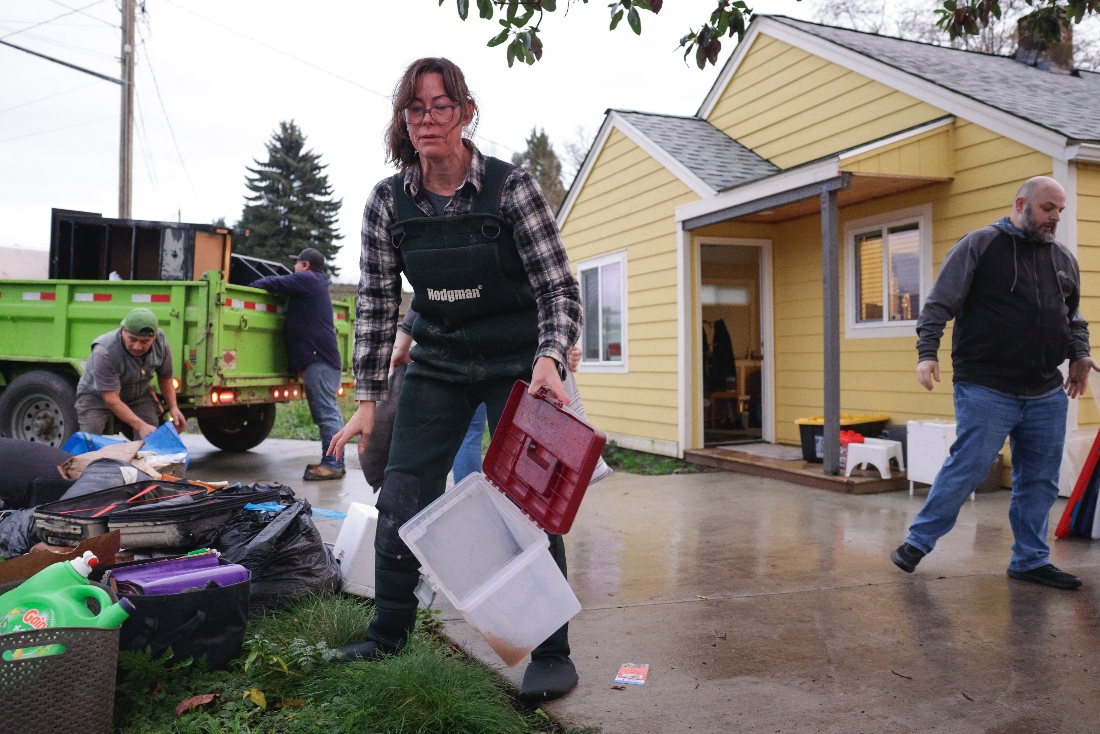 Rachel Popkov throws away damaged items after flood waters from the Skagit River reached her home in Sedro-Woolley, Washington, US. (AFP)