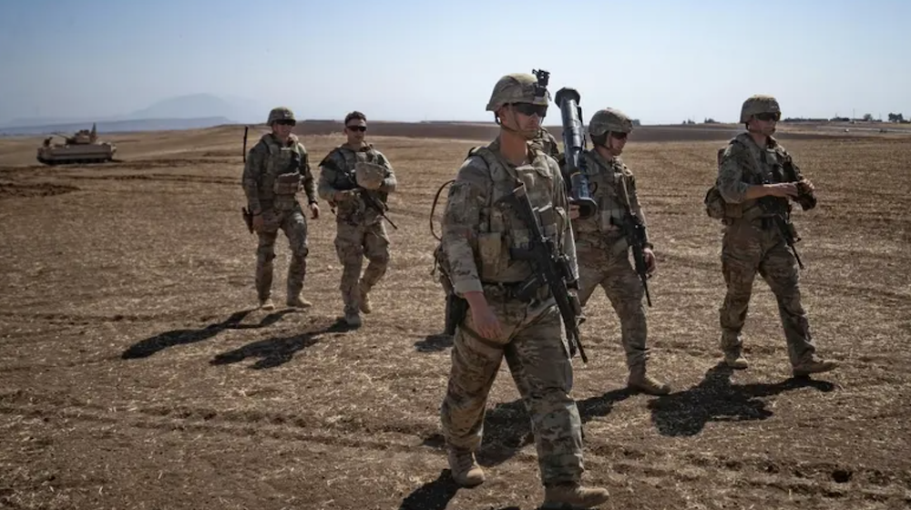 US soldiers walk during a joint military exercise between forces of the US-led “Combined Joint Task Force-Operation Inherent Resolve” coalition against ISIS and members of the Syrian Democratic Forces (SDF) in the countryside of the town of al-Malikiya (Derik in Kurdish) in Syria’s northeastern Hasaka province on September 7, 2022. (AFP/File Photo)