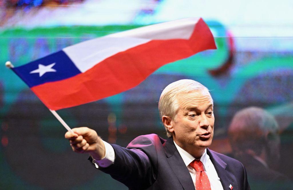 Chile's presidential candidate Jose Antonio Kast, of the Partido Republicano party, waves a Chilean flag after the first exit poll results of the general election in Santiago on November 16, 2025. (Photo by Marvin RECINOS / AFP)