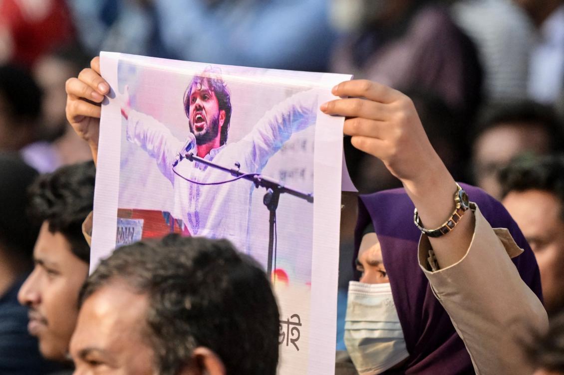 An activist holds a poster of Sharif Osman Hadi, senior leader of the student protest group Inqilab Mancha, who was shot outside a mosque, during a demonstration to condemn the attack in Dhaka on December 15, 2025. (AFP)