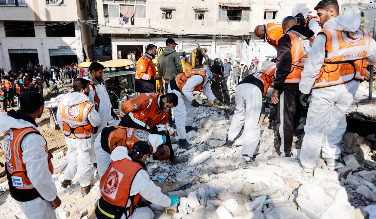 Members of the Palestinian civil defence search for the bodies of the Salem family in the rubble of a building destroyed in 2023 in the Rimal neighbourhood of Gaza City on December 15, 2025. (AFP)