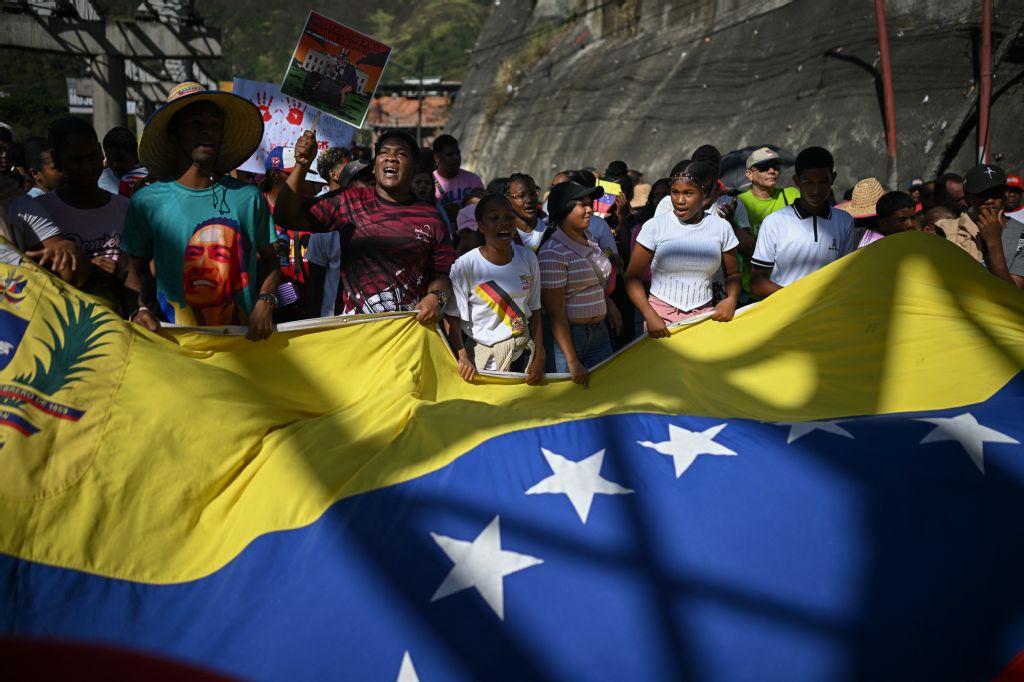 Supporters of Venezuelan President Nicolas Maduro display a giant Venezuelan flag as they take part in a rally in Caracas against US military activity in the Caribbean, Dec. 13, 2025. (Federico PARRA / AFP)