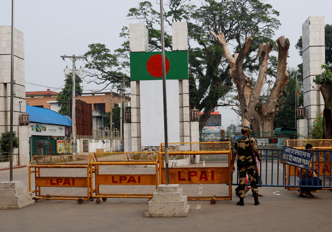 A Border Security Force (BSF) official stands in front of the gates of the India-Bangladesh international border. (Reuters)