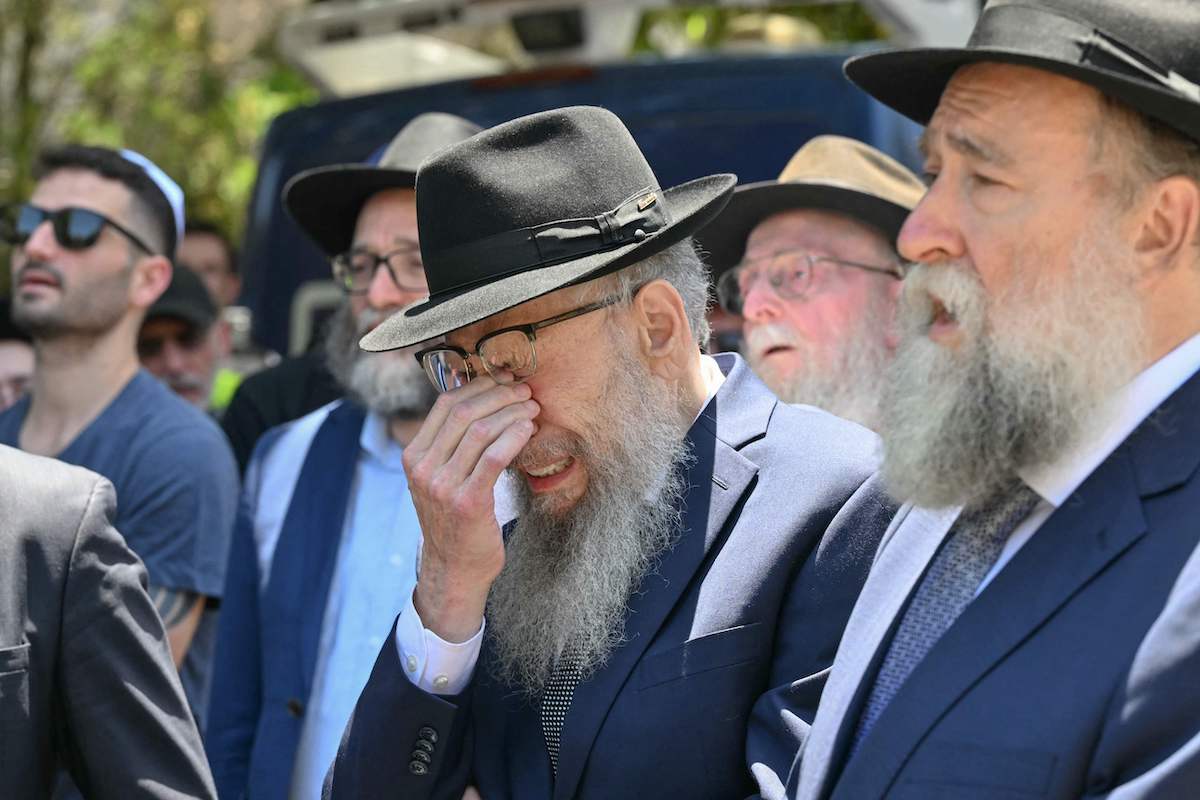 A mourner weeps during the funeral of Rabbi Eli Schlanger, who was killed in the Bondi Beach shooting attack. (AFP)