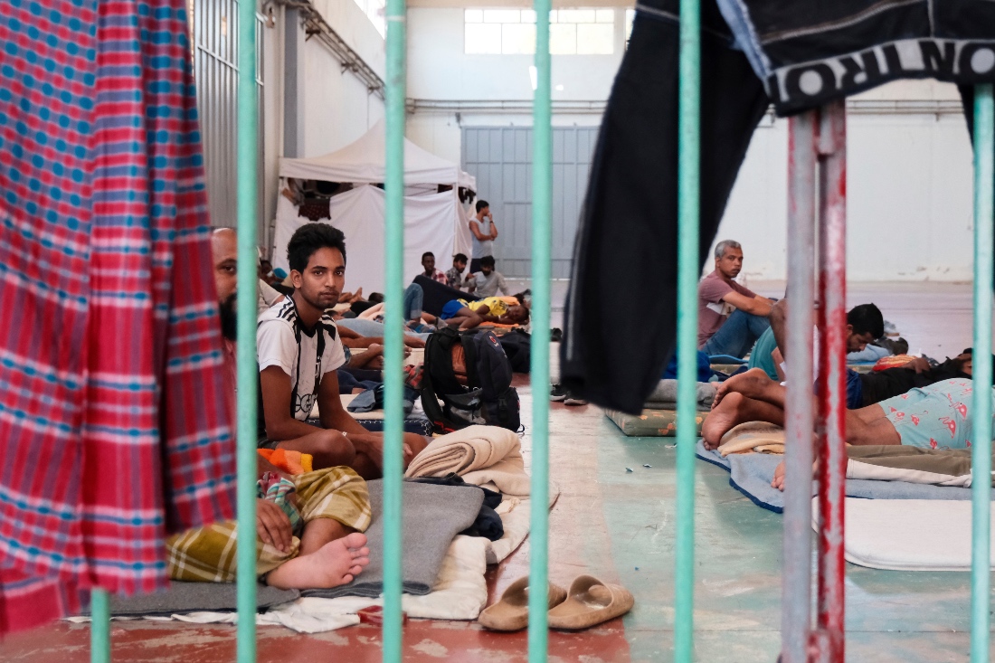 Migrants, who arrived recently at the island of Crete, are held under guard at a temporary shelter in the village of Agia, near Chania, southern Greece. (AP)