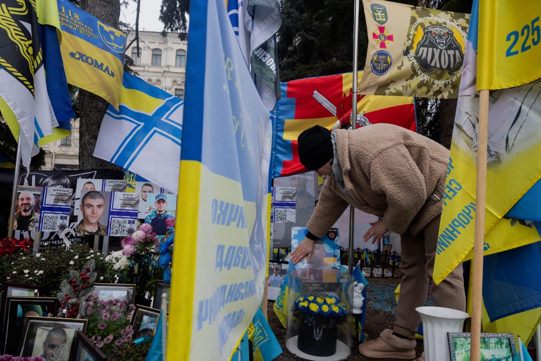 A woman touches a portrait of her deceased husband at a makeshift memorial for fallen Ukrainian and foreign soldiers on the Independence Square in Kyiv, Ukraine. (AFP)