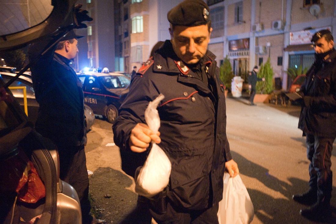A photo dated 2009 shows an Italian policeman holding a bag of cocaine ound in a car in the Scampia area of Naples, Italy. (AFP)