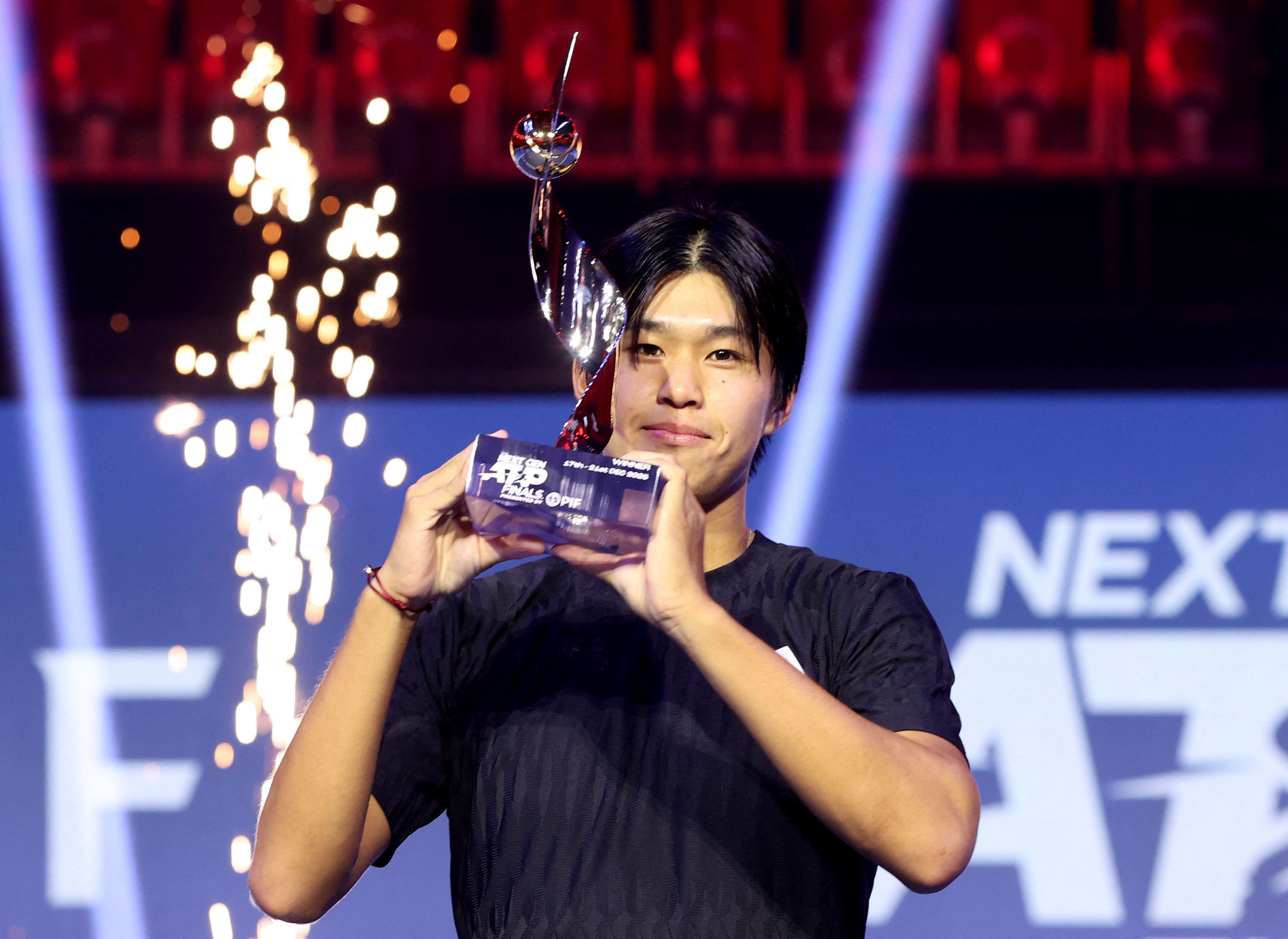 Learner Tien of the US celebrates with the trophy after winning the final match against Belgium’s Alexander Block in the Next Gen ATP Finals at the King Abdullah Sports City in Jeddah on Sunday. (Reuters)
