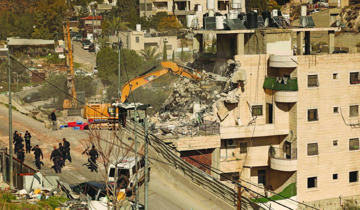 Israeli security forces gather as excavators demolish a building constructed without a permit in the Wadi Qaddum area near the Silwan neighbourhood of east Jerusalem on December 22, 2025. (AFP)