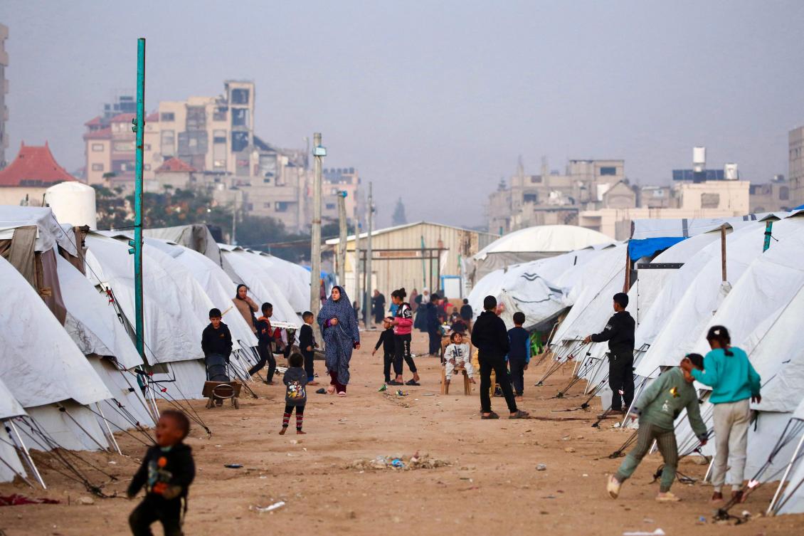 People walk amid shelters at the Nuseirat camp for displaced Palestinians in the central Gaza Strip on Monday. (AFP)