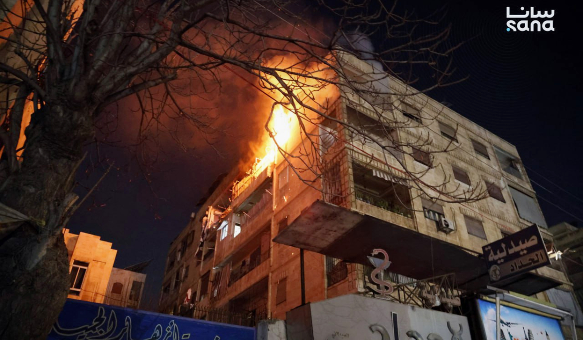 This photo released by the official Syrian news agency SANA, shows flames rising from a building after clashes broke out between security forces and Kurdish fighters in neighborhoods of the northern Syrian city of Aleppo, Syria, Monday, Dec. 22, 2025. (AP)