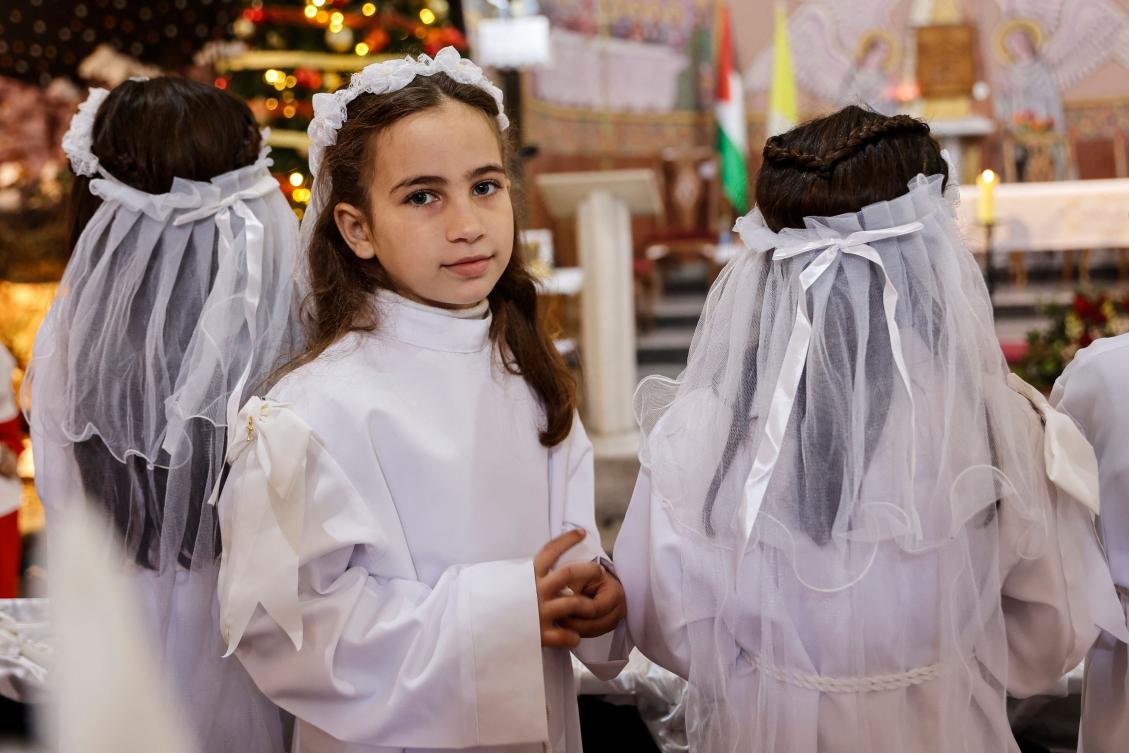 A young Christian worshipper attends Christmas celebrations at the Holy Family Parish in Gaza City on December 21, 2025. (Photo by Omar AL-QATTAA / AFP)