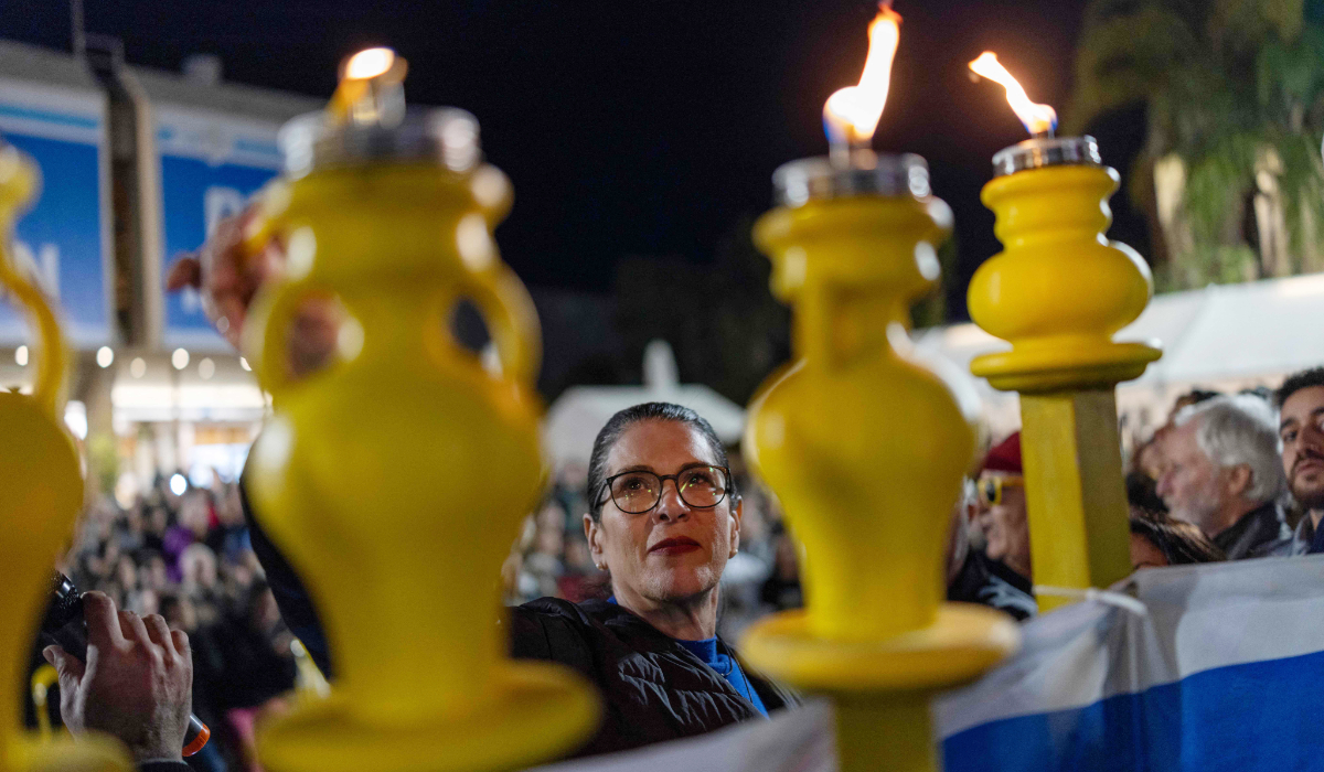 Talik Gvili, mother of a hostage Ran Gvili, lights a candle as Israelis light the 8th candle of Hannukah in Hostage Square in Tel Aviv on December 21, 2025, as they call for the return her son's remains. (AFP)