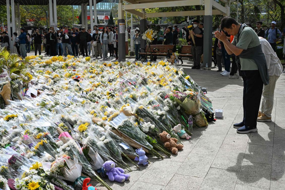 (FILES) People lay flowers outside the Wang Fuk Court apartment blocks in the aftermath of the deadly November 26 fire in Hong Kong's Tai Po district on December 1, 2025. (AFP)