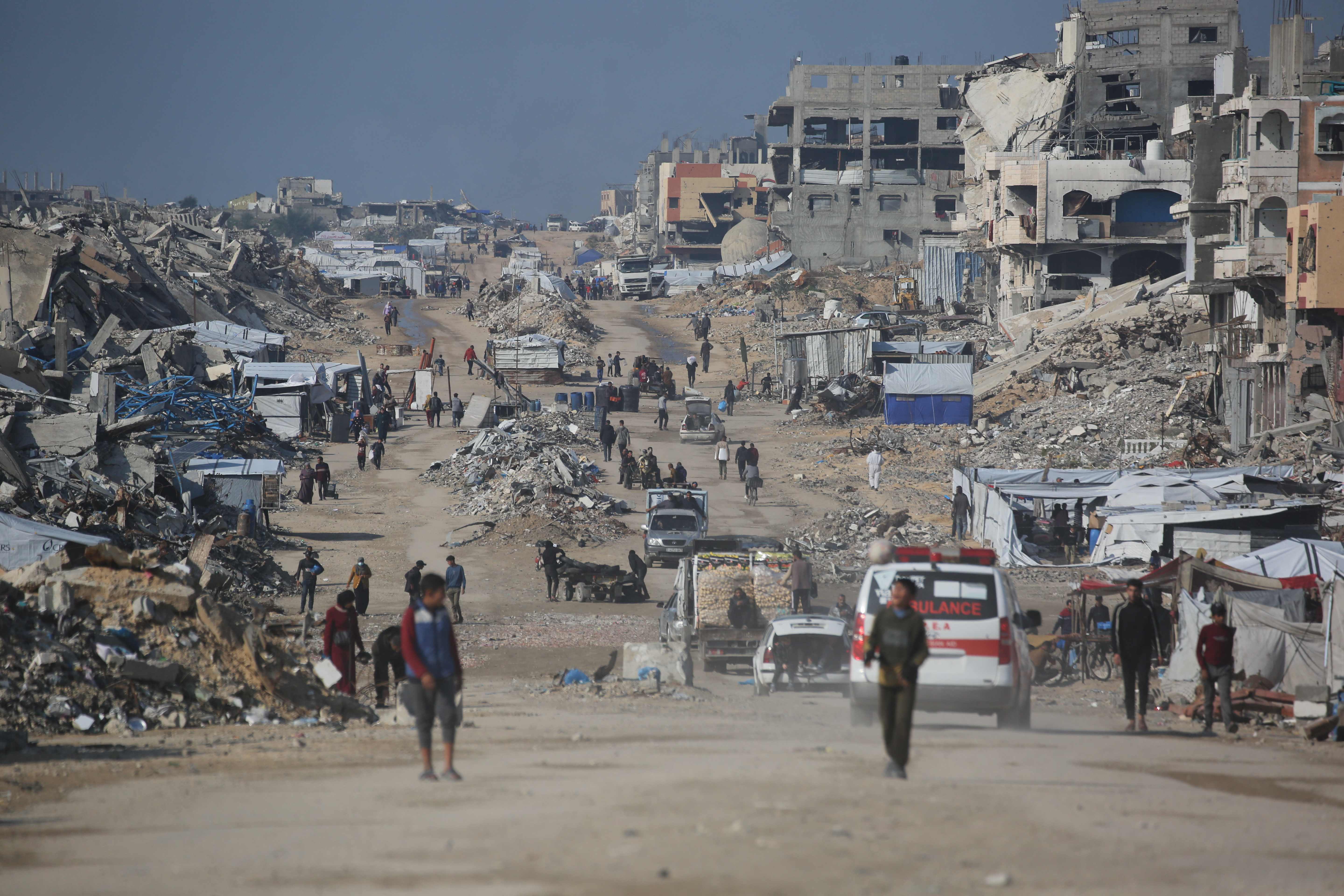 Palestinians walk in a street next to the rubble of destroyed buildings in Jabalia refugee camp, in northern Gaza on Wednesday. (AFP)