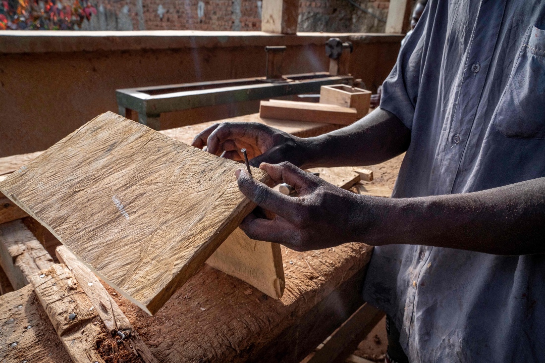 A man works as a carpenter in a workshop dedicated to training former child soldiers in Bunia, DR Congo. (AFP)