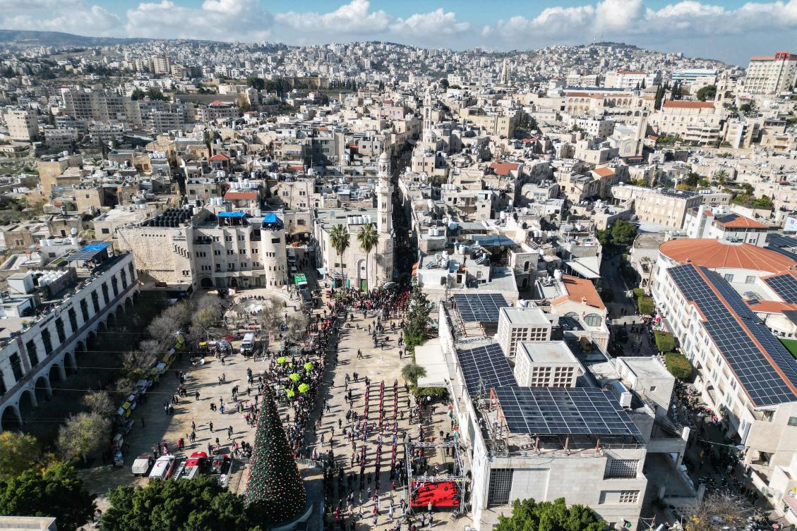 An aerial view shows scouts marching during Christmas eve celebrations on Manger Square outside the Church of the Nativity in Bethlehem, in the Israeli-occupied West Bank, on December 24, 2025. (AFP)