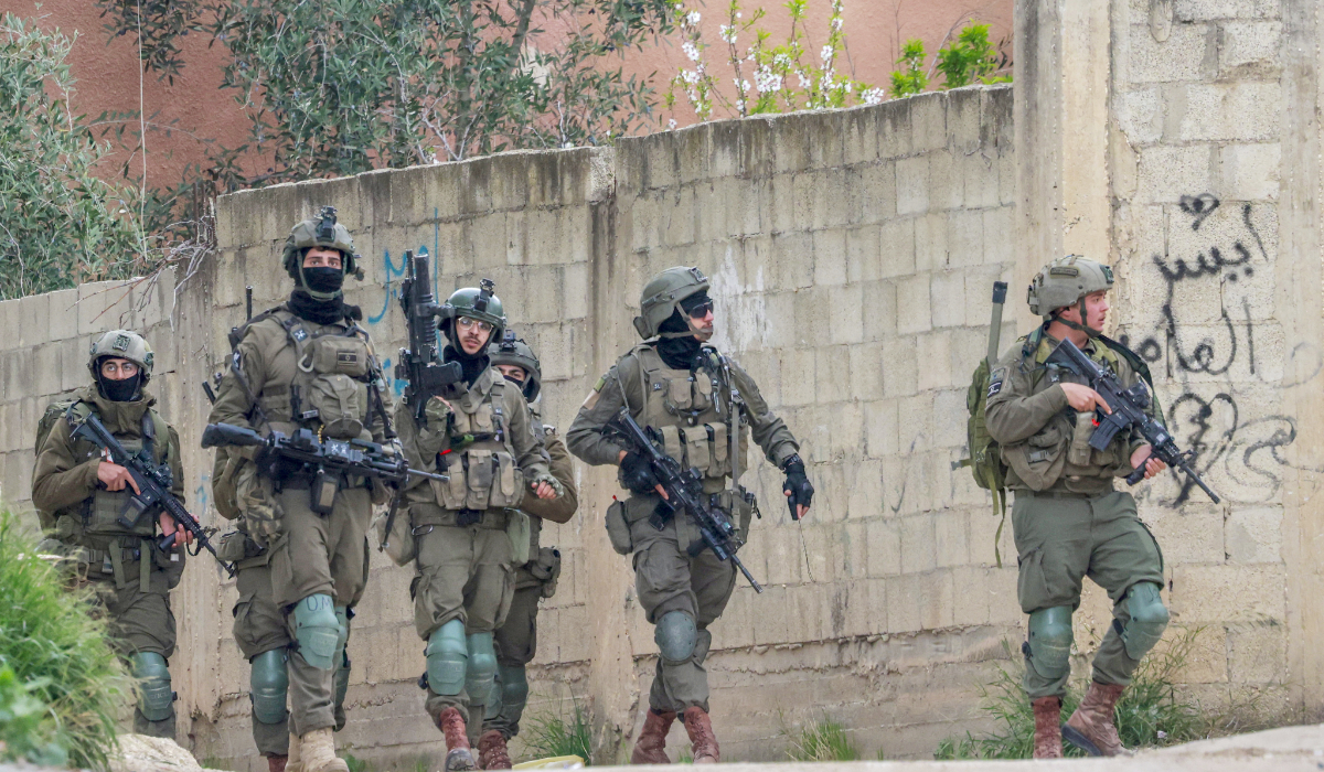 Israeli soldiers walk during a raid in the occupied-West Bank city of Qabatiya, north of Jenin, on February 23, 2025. (AFP)