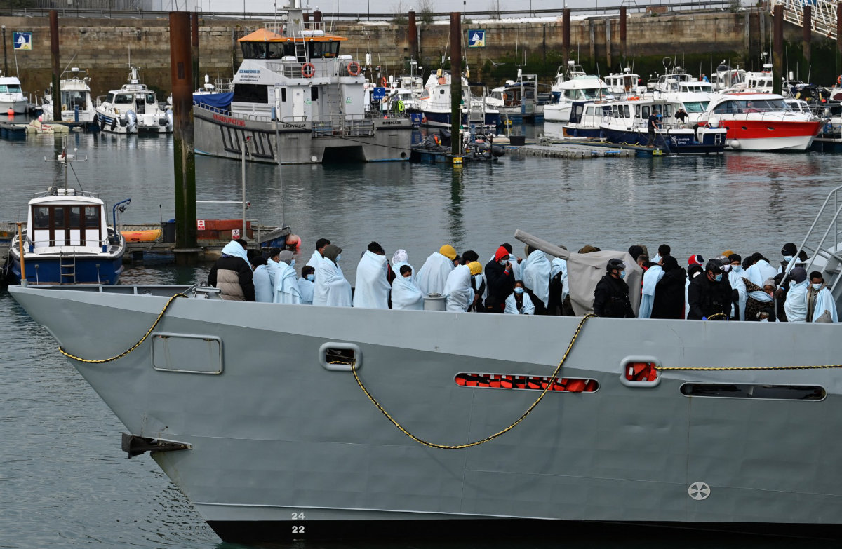 In this photo taken on April 14, 2022, migrants huddle together under blankets, brought to port by the UK Border Force after being picked up crossing the English Channel from France. (AFP/File)