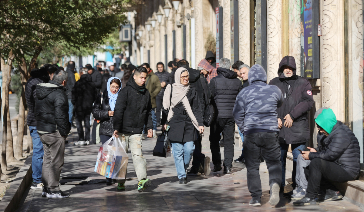 People walk past stores as the value of the Iranian Rial drops, in Tehran, Iran, December 30, 2025. (REUTERS)