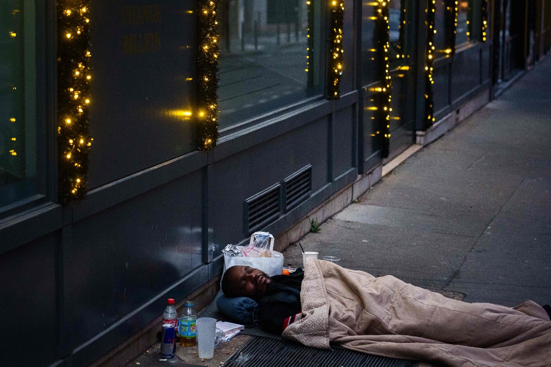 A homeless person sleeps over a heating duct in central Paris, France. (AFP)
