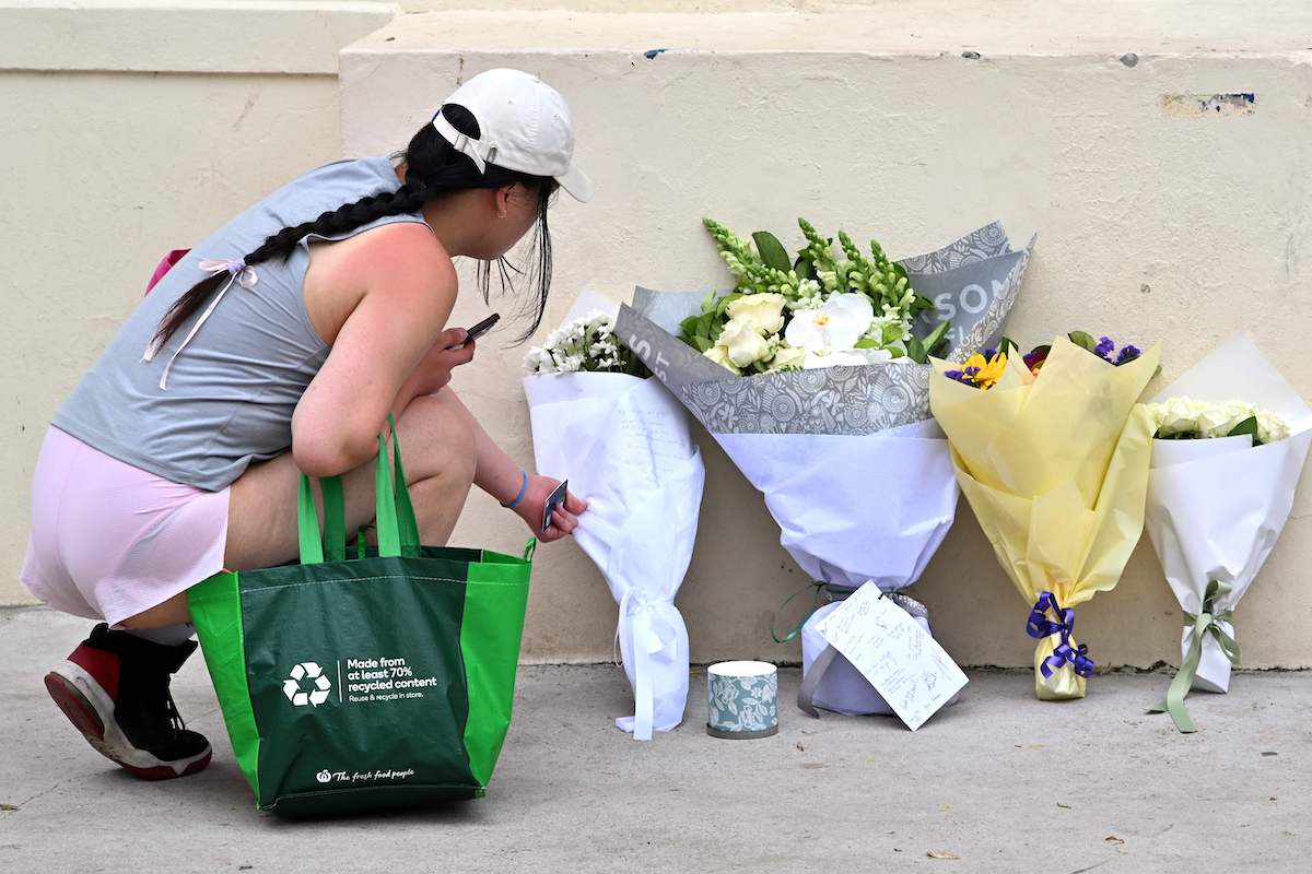 A mourner places flowers near the Bondi Pavilion where gunmen attacked the Jewish festival of Hanukkah, killing 15. (AFP)