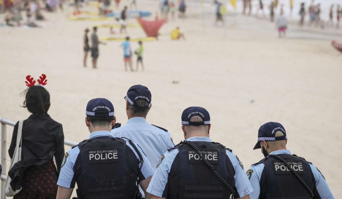 Police officers patrol near beachgoers on Christmas Day at Bondi Beach in Sydney on December 25, 2025. (AFP)
