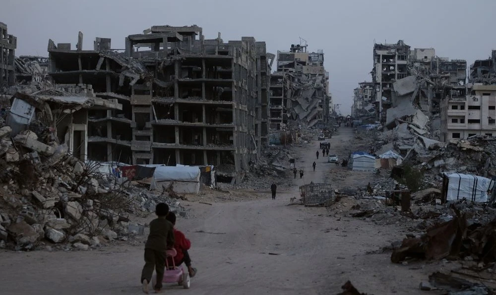 Palestinians walk through Al-Karama, Gaza City, Nov. 30, 2025. (AP Photo)