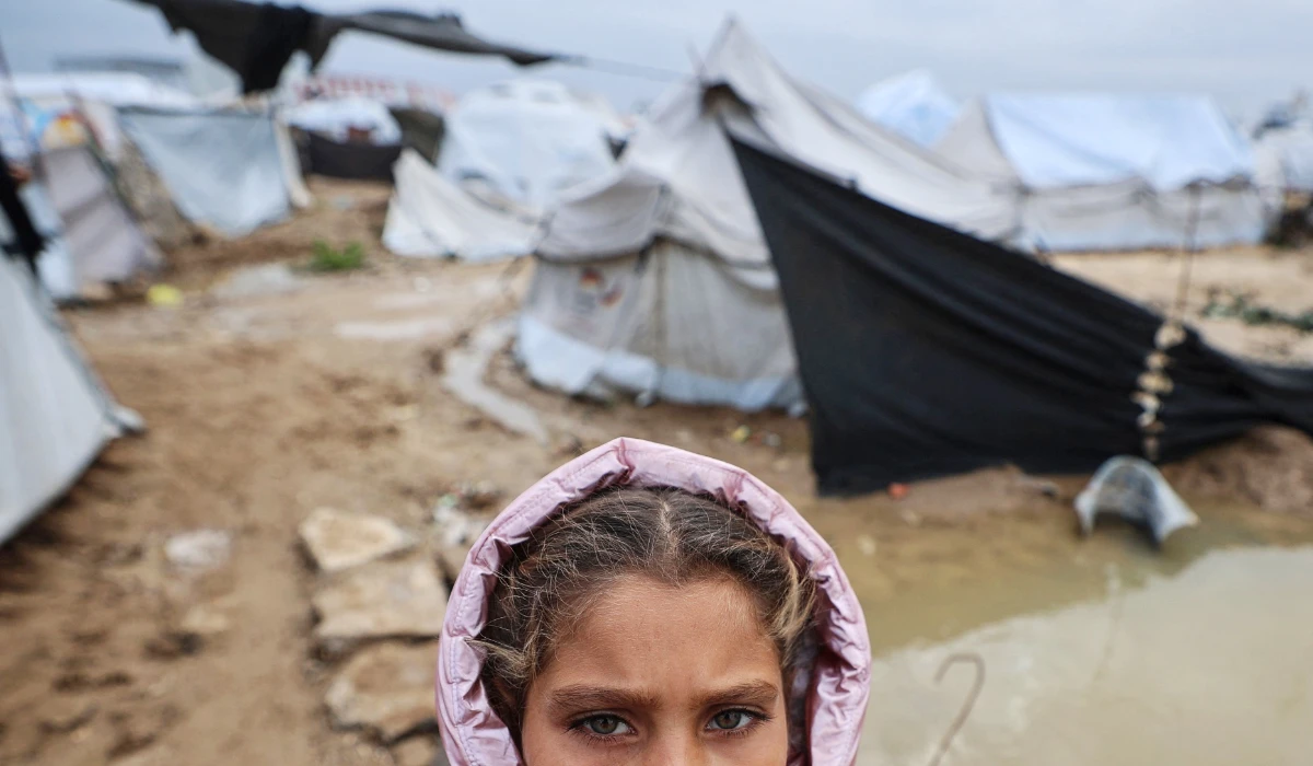 A displaced Palestinian girl looks on as she stands amid tents and makeshift shelters in the Bureij refugee camp in Gaza. (AFP)