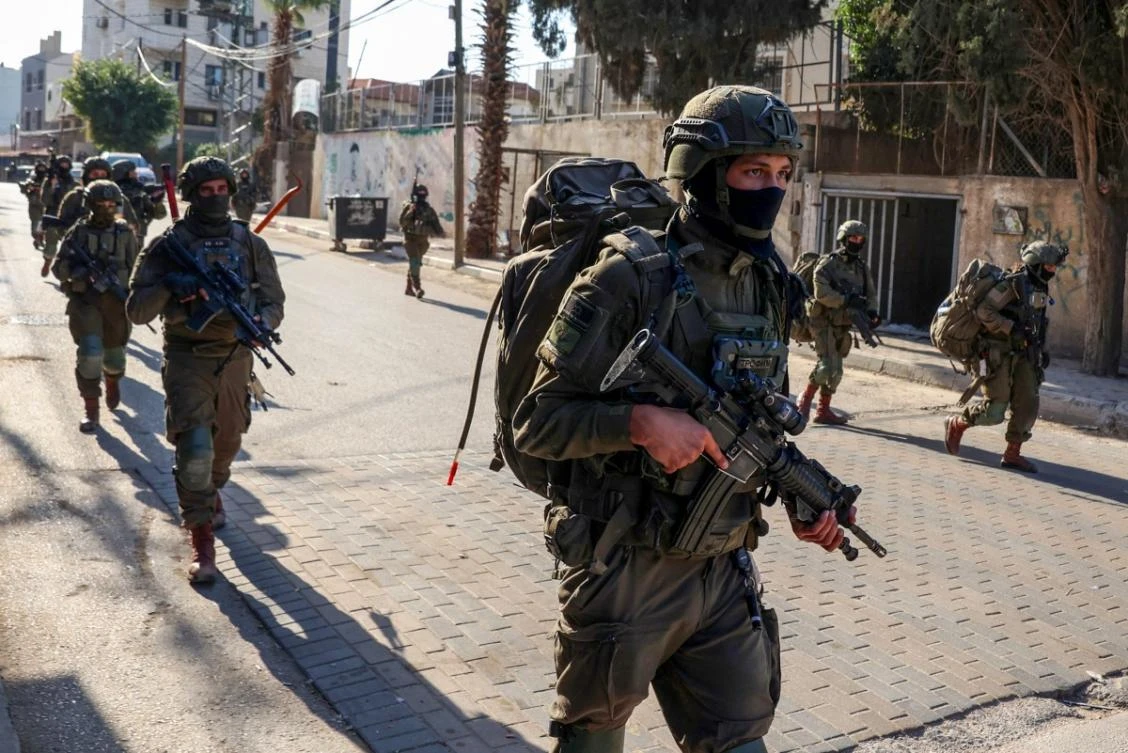 Israeli soldiers walk during a military operation in the town of Qalqiya, in the occupied West Bank on December 4, 2025. (AFP)