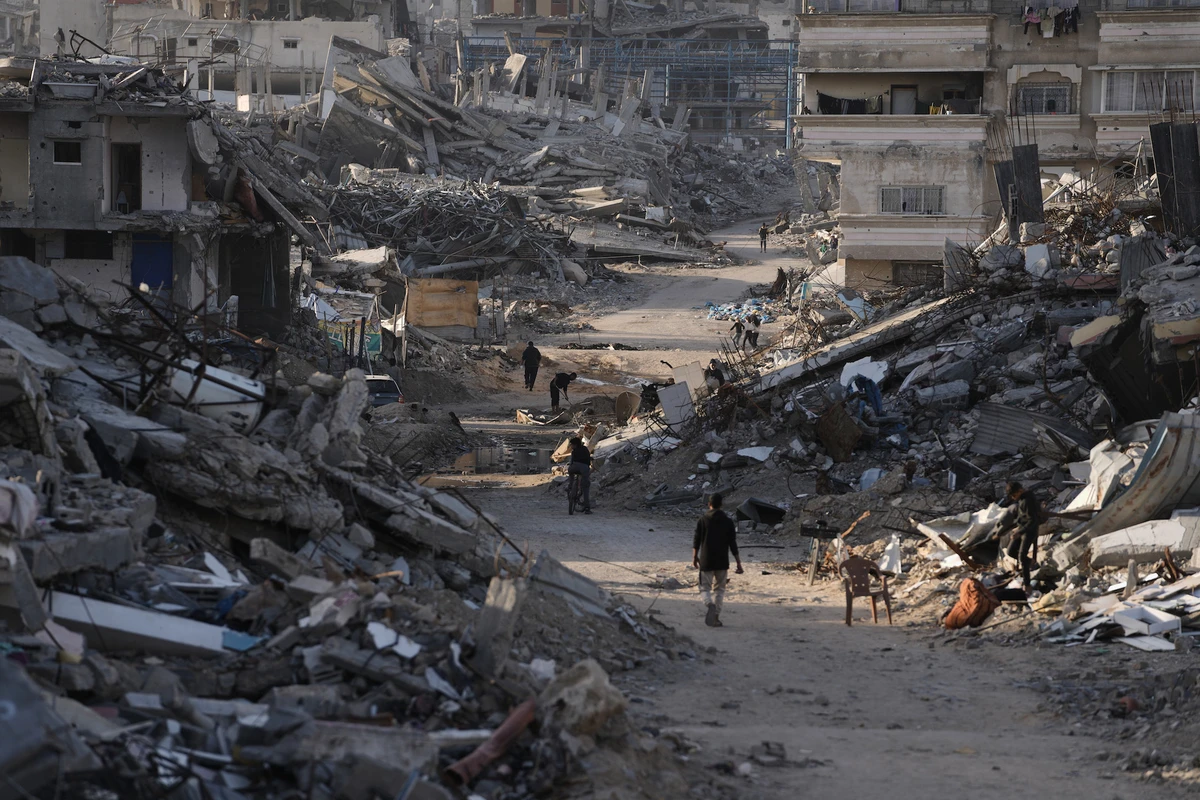 People walk among destroyed buildings in Jabalia, in the northern Gaza Strip, Sunday, Dec. 7, 2025. (AP)