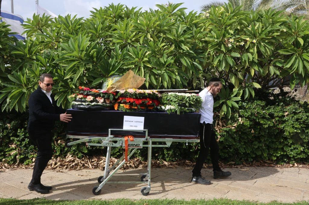 A member of a repatriation company prepare the coffin of Thai national Sudthisak Rinthalak at Ben-Gurion Airport on December 9, 2025. (AFP)