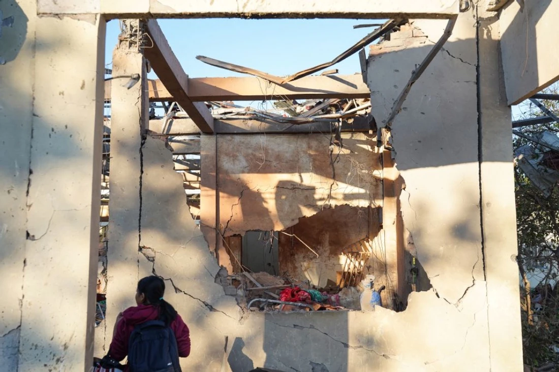 A woman inspects a hospital damaged in a Myanmar military air strike that killed more than 30 people in Mrauk U, western Rakhine state, Myanmar. (AFP)