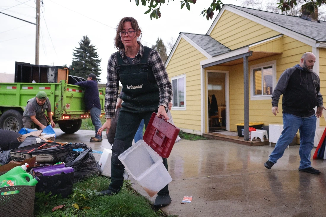 Rachel Popkov throws away damaged items after flood waters from the Skagit River reached her home in Sedro-Woolley, Washington, US. (AFP)