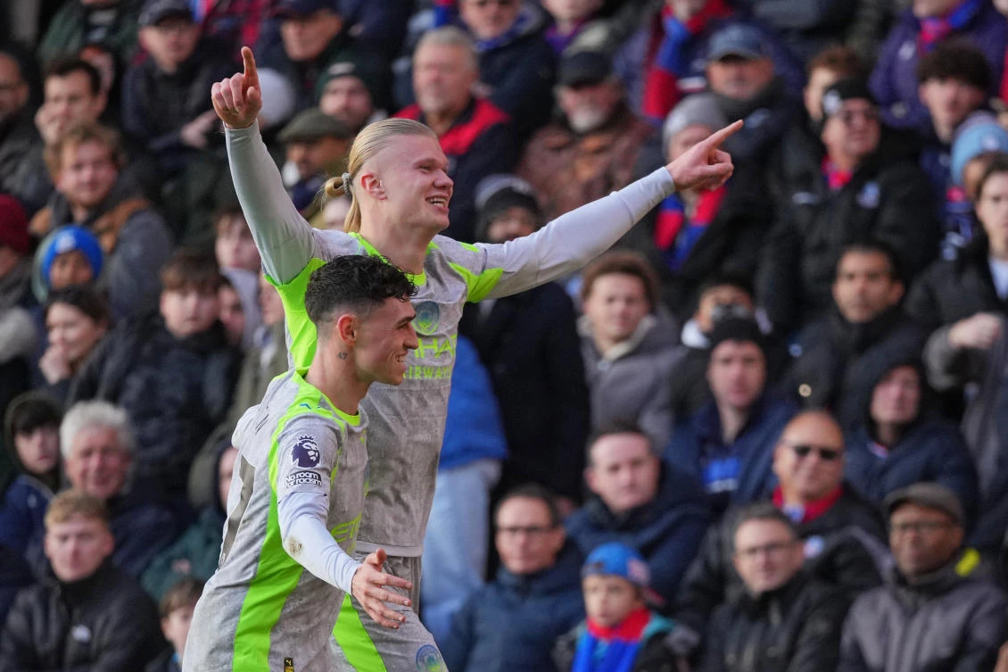 Manchester City’s Erling Haaland celebrates with Manchester City’s Phil Foden after scoring his side’s opening goal during the English Premier League soccer match between Crystal Palace and Manchester City in London. (AP)