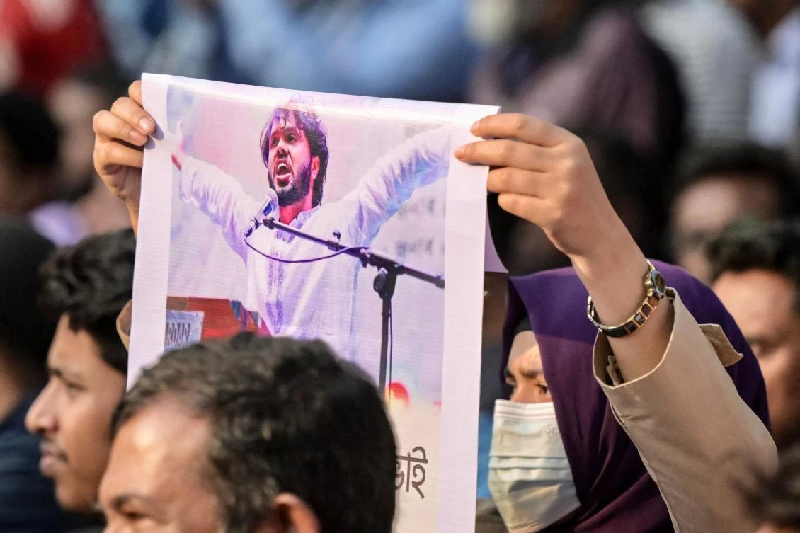An activist holds a poster of Sharif Osman Hadi, senior leader of the student protest group Inqilab Mancha, who was shot outside a mosque, during a demonstration to condemn the attack in Dhaka on December 15, 2025. (AFP)
