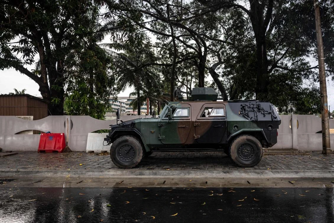 An armored vehicle is positioned at the entrance of a blocked road next to the National Television, Benin TV, in Cotonou, on Dec. 8, 2025. (AFP)