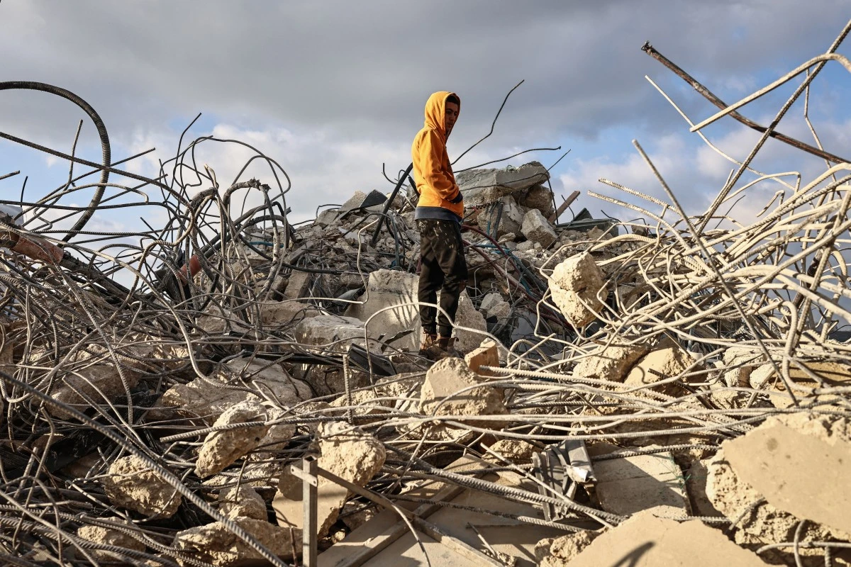 A man stands on the rubble of a Palestinian house that was demolished by the Israeli army in the village of Qalandia, south of Ramallah in the Israeli-occupied West Bank, Dec. 16, 2025. (AFP)