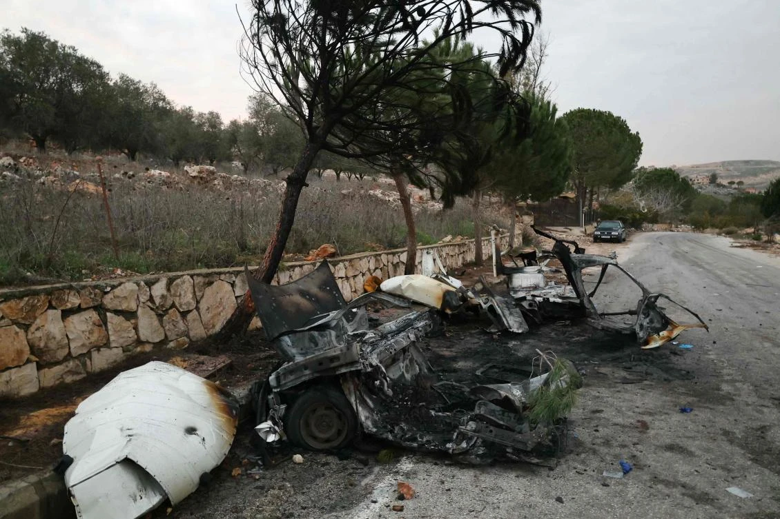 The wreckage of a vehicle, targeted in an Israeli airstrike, lies by the side of a road linking the southern Lebanese villages of Odeisseh and Markaba, Dec. 16, 2025. (AFP)