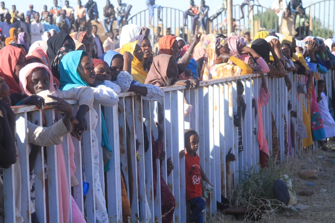 Women and children stand near fences as authorities of the capital, Khartoum, are deploying thousands of soldiers in the Umbada locality west of Omdurman, Sudan. (AFP)
