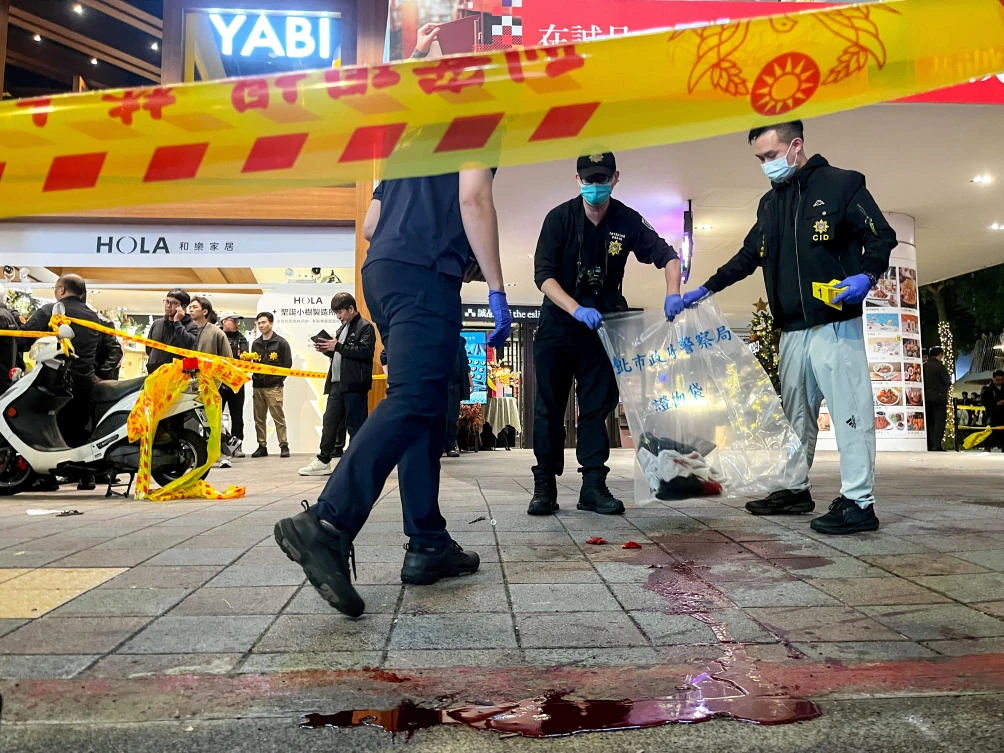 Police collect evidence from a crime scene outside Eslite Spectrum Nanxi store near Zhongshan station as the area is cordoned off with yellow crime scene tape, following an incident in which several were injured after a person released smoke bombs and attacked bystanders, in Taipei, Dec. 19, 2025. (Reuters)
