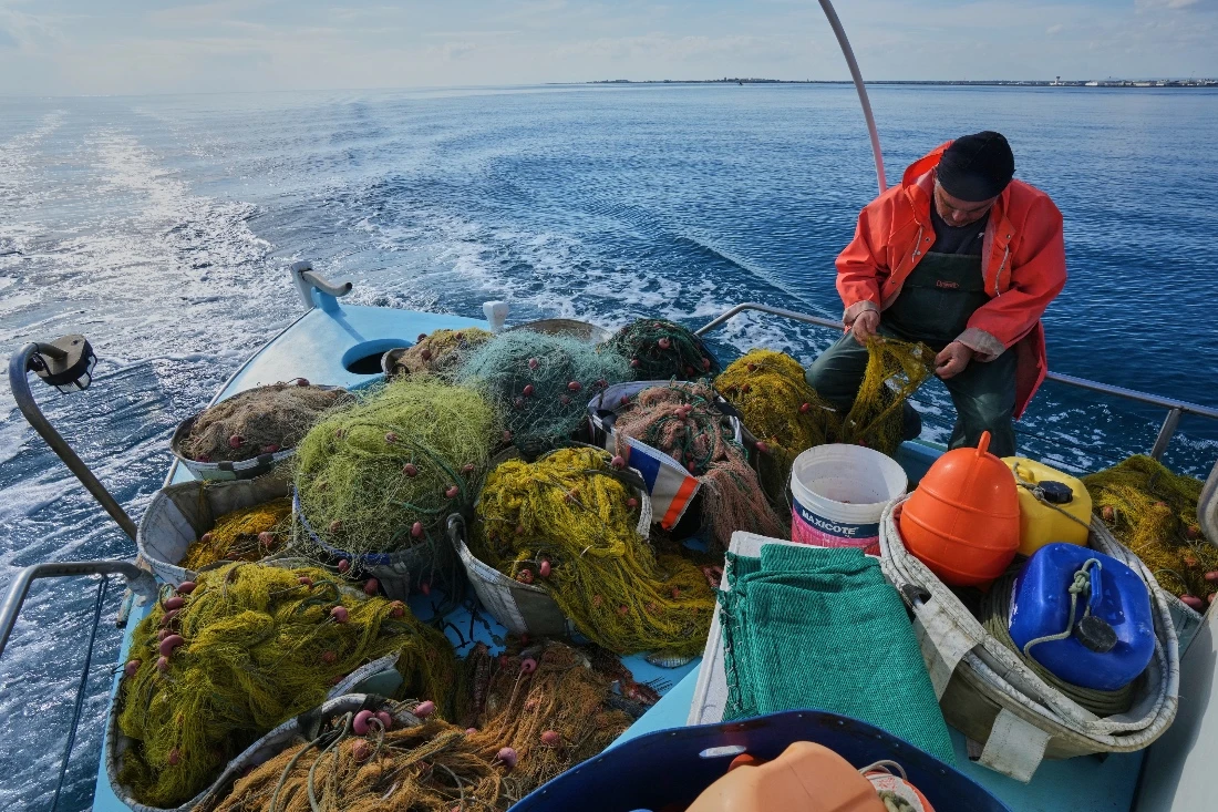Fisherman Photis Gaitanos collects fish from nets off the coast of Larnaca, Cyprus. (AP)