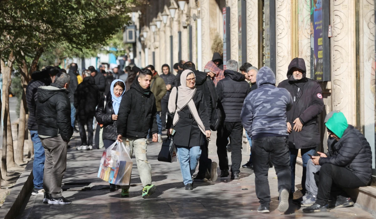 People walk past stores as the value of the Iranian Rial drops, in Tehran, Iran, December 30, 2025. (REUTERS)