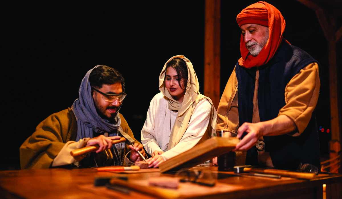 The team at ‘Ikmah After Dark: Secrets of the Scribe’ showing a visitor how to carve on a stone. (Supplied)