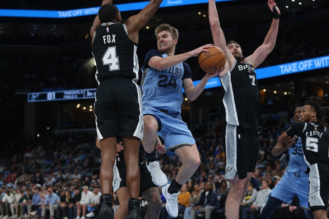 Memphis Grizzlies guard Cam Spencer drives to the basket as San Antonio Spurs guard De'Aaron Fox (4) and center Luke Kornet defend during the third quarter of an NBA basketball game at FedExForum Tuesday. (Petre Thomas-Imagn Images)
