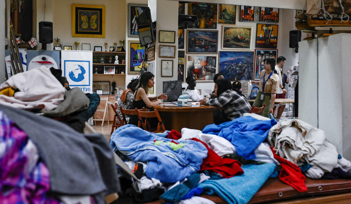 A picture taken on June 26, 2023, shows migrants receiving food and clothes from an NGO in Athens. (AFP)